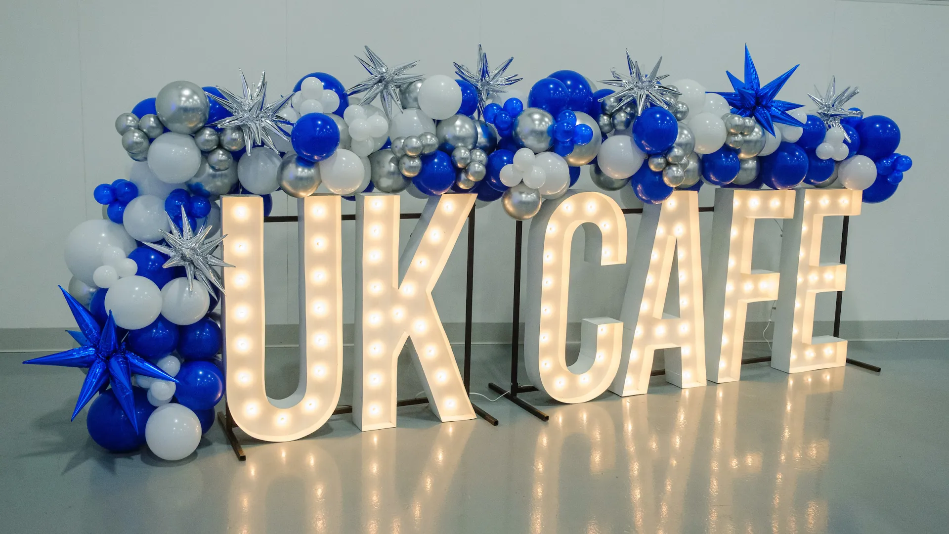 UK CAFE in lights surrounded by balloons